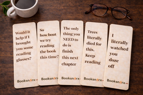 Five wooden bookmarks with humorous text on a wooden surface with a cup of coffee and glasses.
